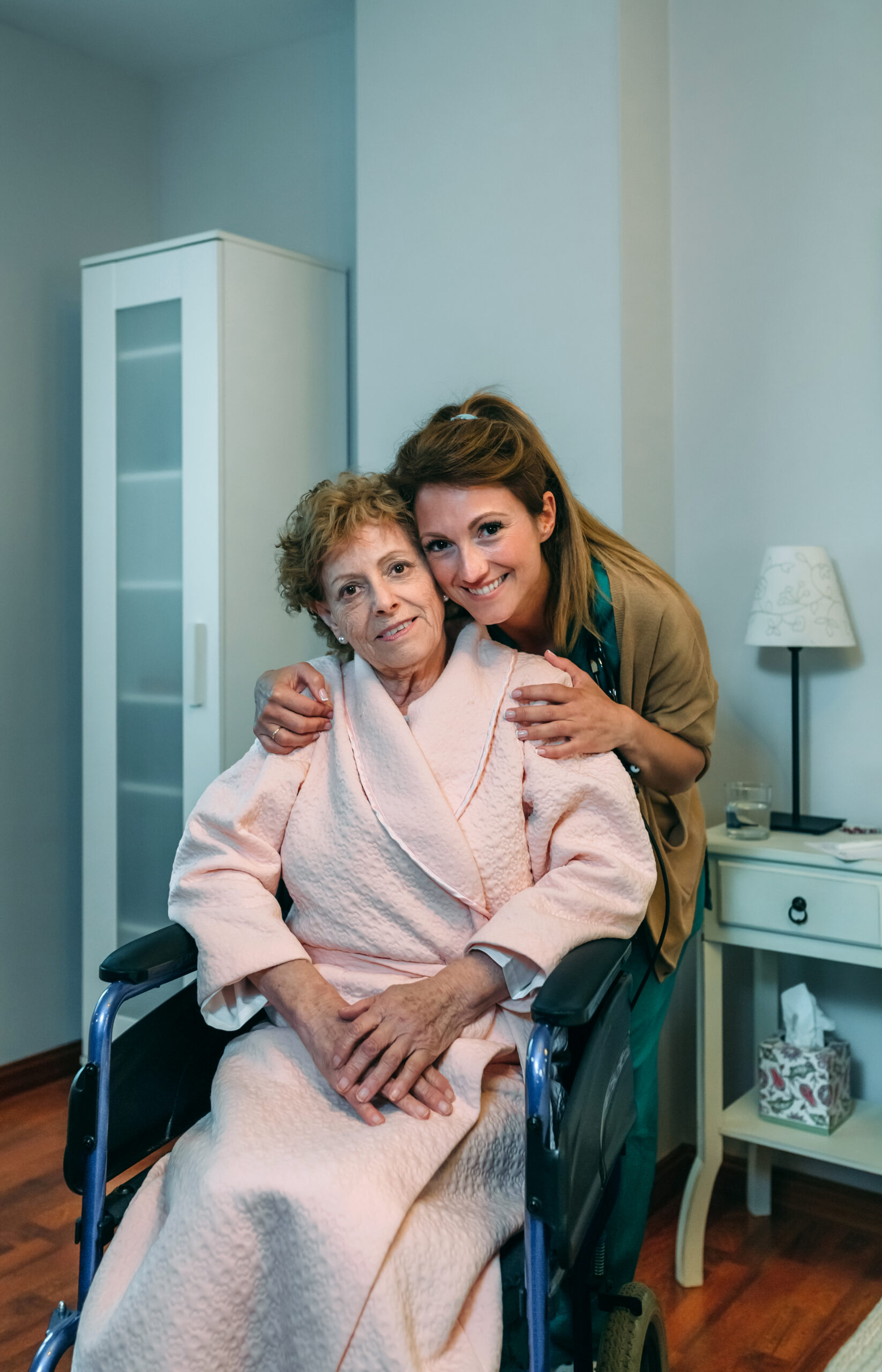 Affectionate female caretaker posing with elderly female patient